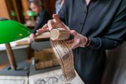 Knihovědkyně Lenka Veselá drží v rukou tzv. Kristovu délku – unikátní tiskovinu (patří mezi tzv. pověrečné tisky), která v minulosti sloužila jako ochrana například rodičce při porodu. Pruh papíru nebo látky potištěný modlitbami se obvykle přikládal přímo na tělo, aby nositelce přinesl štěstí. 