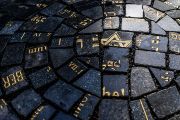 Výtvarníci Lucie a Jaroslav Rónovi působivý památník sestavili ze dvou stovek kostek, které v druhé polovině 20. století dláždily část Václavského náměstí. Surovinu pro jejich výrobu tvořily kameny ze starých židovských (ale i křesťanských) náhrobků z různých míst Československa. 