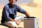 Jan Mrlina s gravimetrem Scintrex CG-3 na pouštních dunách