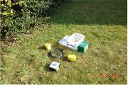 Ukázka vybavení seismické stanice s geofonem (žlutá krabička), digitizérem (šedo-černé zařízení) a suchou alkalickou baterií, která se používá pro elektrické ohradníky a neobsahuje olovo, rtuť ani kadmium (zelený kvádr). Geofon je celý zakopaný pod zemí, baterie a digitizér jsou umístěny v boxu částečně skrytém pod zemí. Ochranný box vyčnívá asi 5 cm nad povrch.