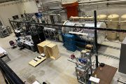 Zařízení SELINA v popředí, v pozadí akcelerátor Pelletron v laboratoři Dust Accelerator Laboratory. Akcelerátor simuluje nárazy prachových částic při vysoké rychlosti a slouží ke kalibraci přístrojů pro kosmické mise.